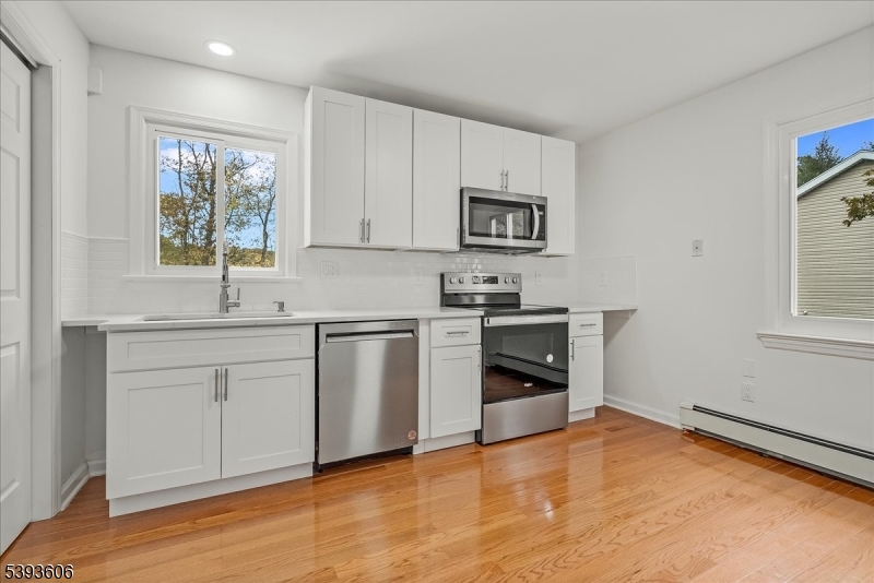 60 Kenvil Avenue Succasunna, NJ 07876 - Photo 7 of 28 a kitchen with white cabinets and appliances