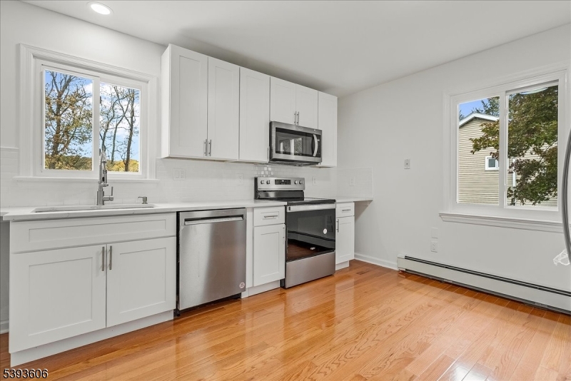 60 Kenvil Avenue Succasunna, NJ 07876 - Photo 9 of 28 a kitchen with stainless steel appliances granite countertop a stove a sink and a microwave