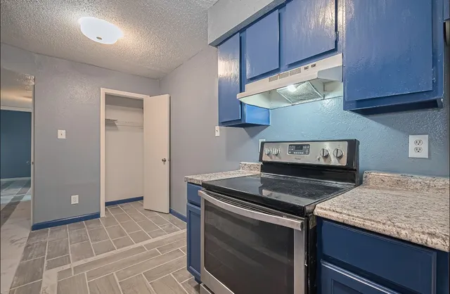 a kitchen with granite countertop a stove and a sink