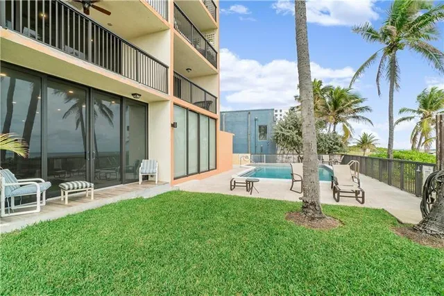 a view of a chair and table in backyard of the house