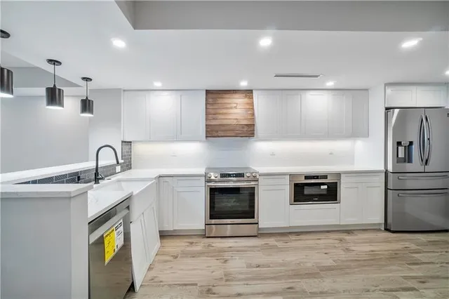 a kitchen with stainless steel appliances granite countertop a stove a sink and a refrigerator