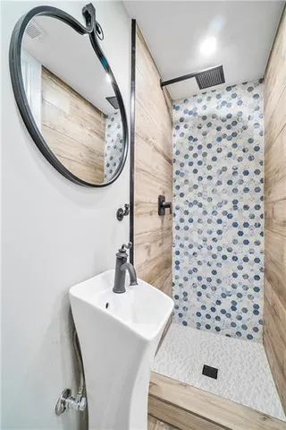 a bathroom with a sink a mirror and a shower