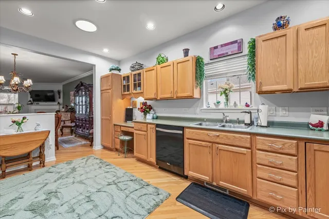 a room with stainless steel appliances kitchen island granite countertop a sink and a white wooden cabinets