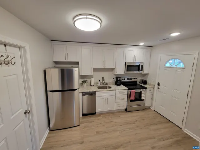 a kitchen with stainless steel appliances granite countertop a refrigerator sink and stove