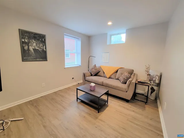 a living room with furniture and a wooden floor