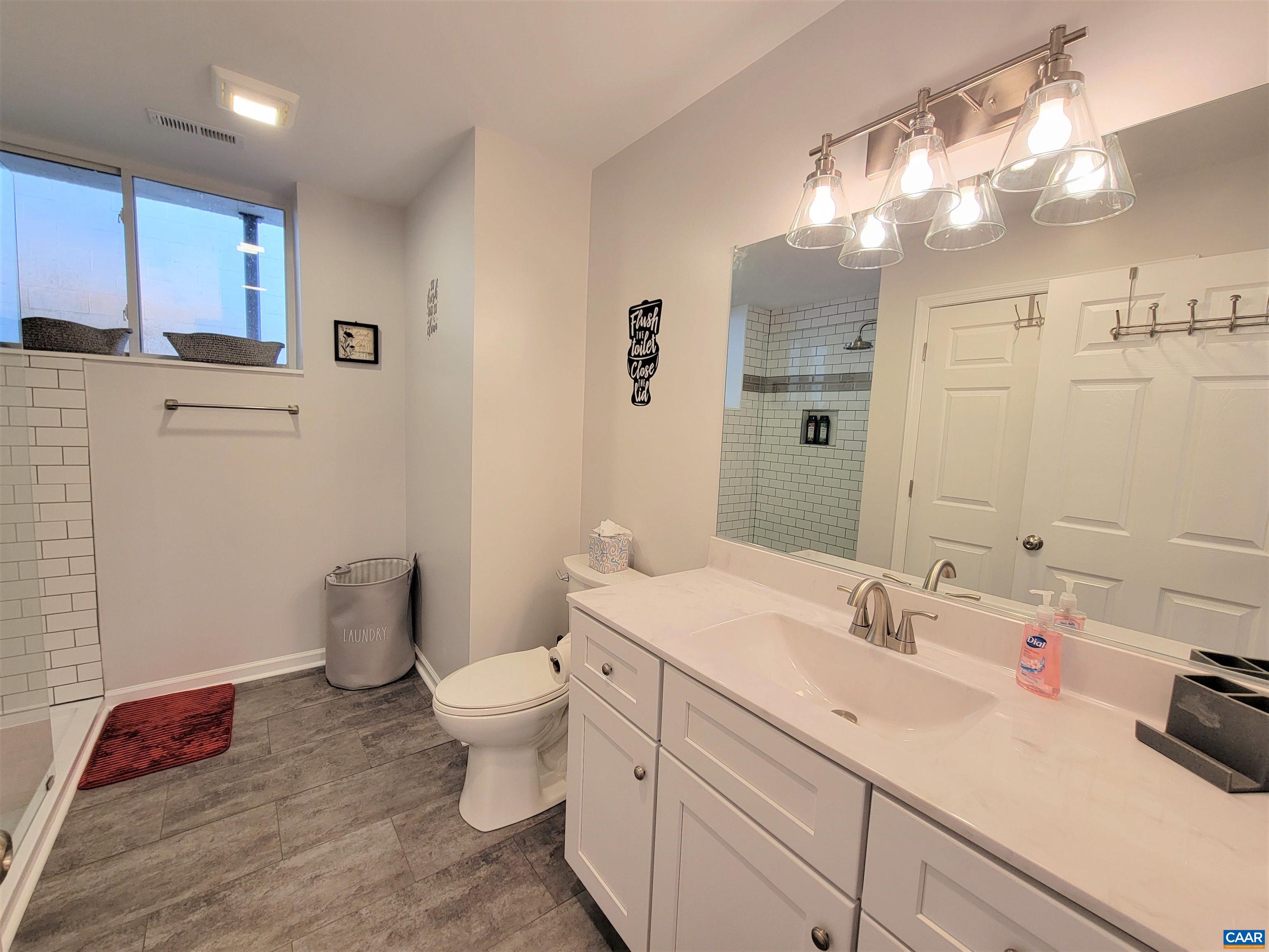 1511 East High Street, Unit 3 Charlottesville, VA 22902 - Photo 5 of 13 a bathroom with a sink a toilet and shower
