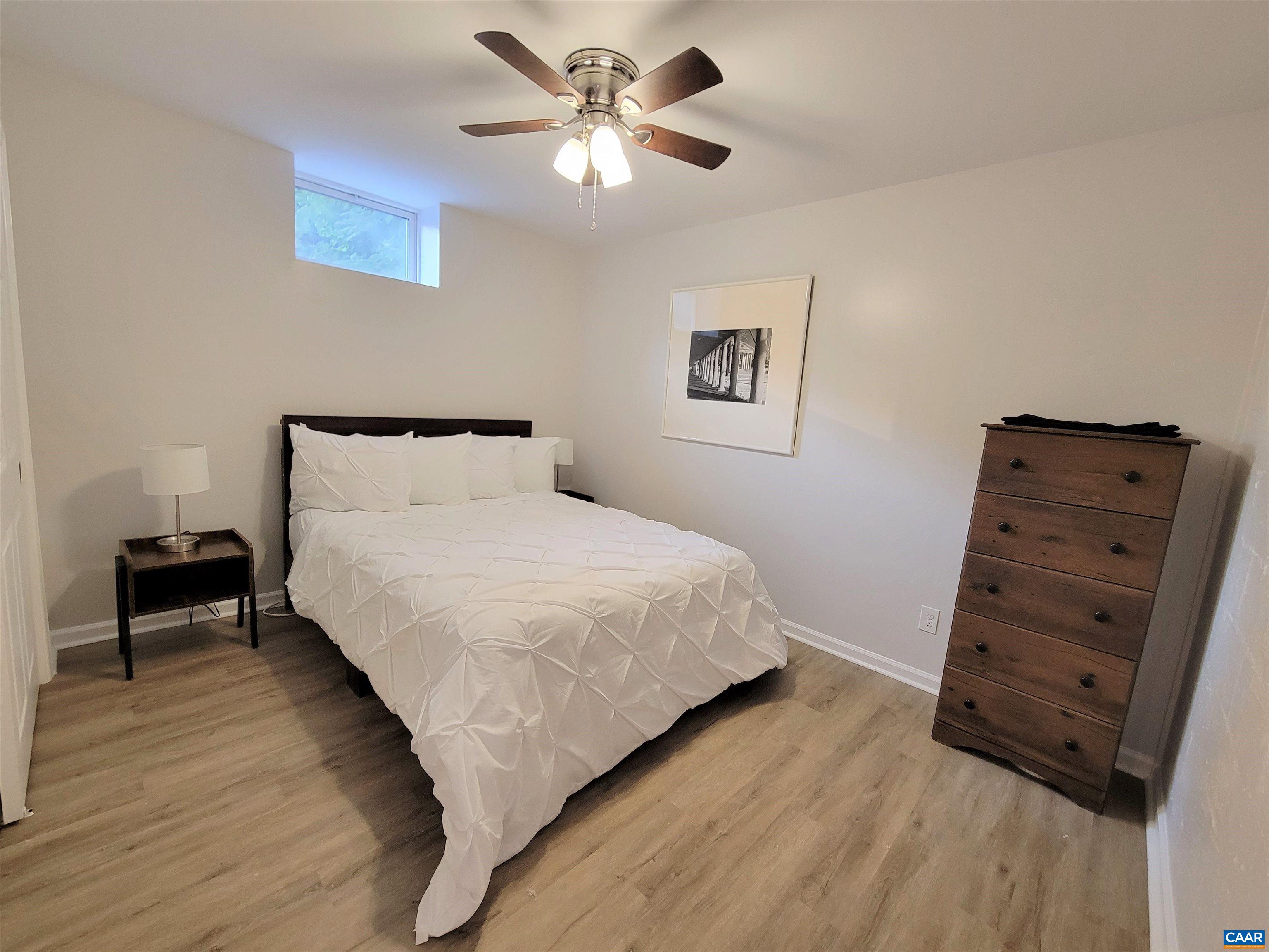 1511 East High Street, Unit 3 Charlottesville, VA 22902 - Photo 6 of 13 a bedroom with a bed and a chandelier