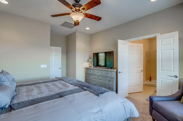 a bedroom with a large bed and a chandelier