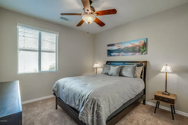 a view of a backyard with lawn chairs under an umbrella