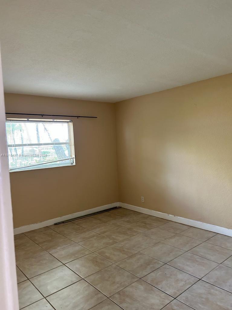 2607 Northeast 8th Avenue, Unit 19 Wilton Manors, FL 33334 - Photo 6 of 11 an empty room with windows