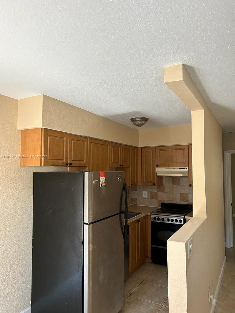 2607 Northeast 8th Avenue, Unit 19 Wilton Manors, FL 33334 - Photo 7 of 11 a kitchen with a refrigerator and a stove