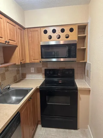 a kitchen with stainless steel appliances granite countertop a sink and a stove