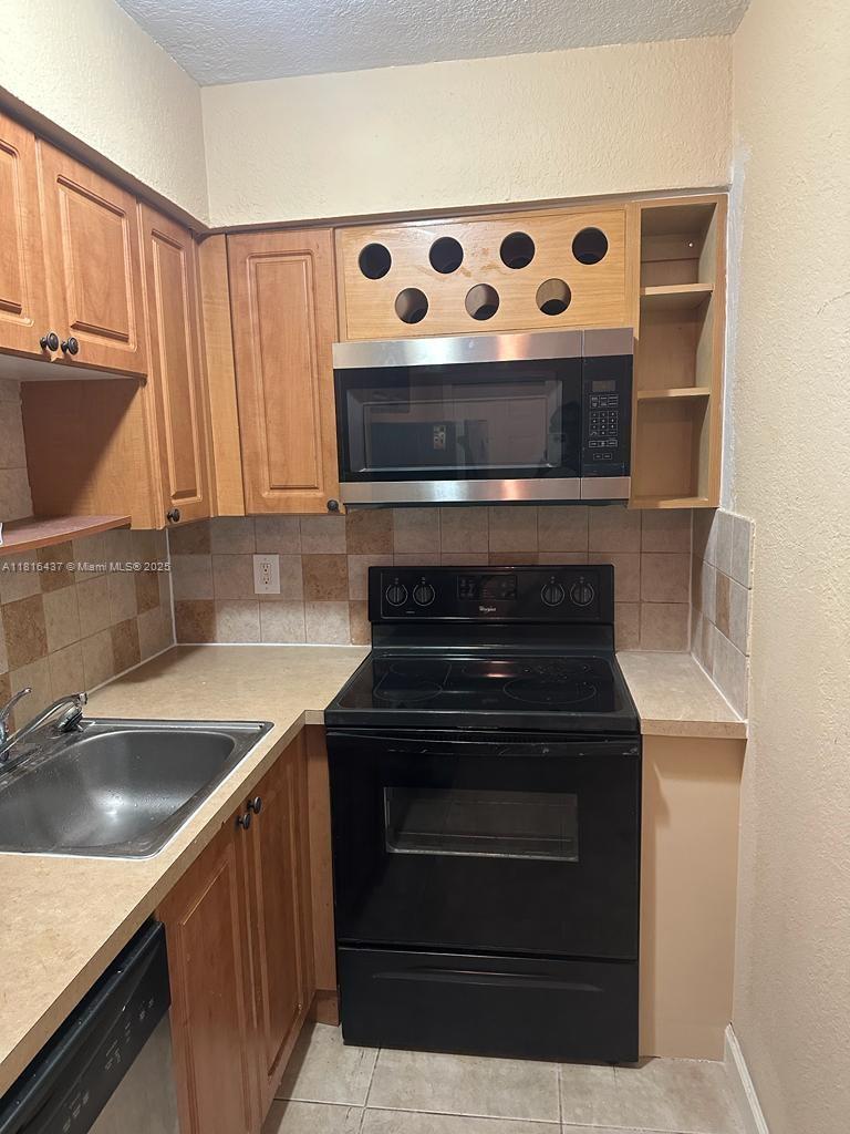 2607 Northeast 8th Avenue, Unit 19 Wilton Manors, FL 33334 - Photo 9 of 11 a kitchen with stainless steel appliances granite countertop a sink and a stove