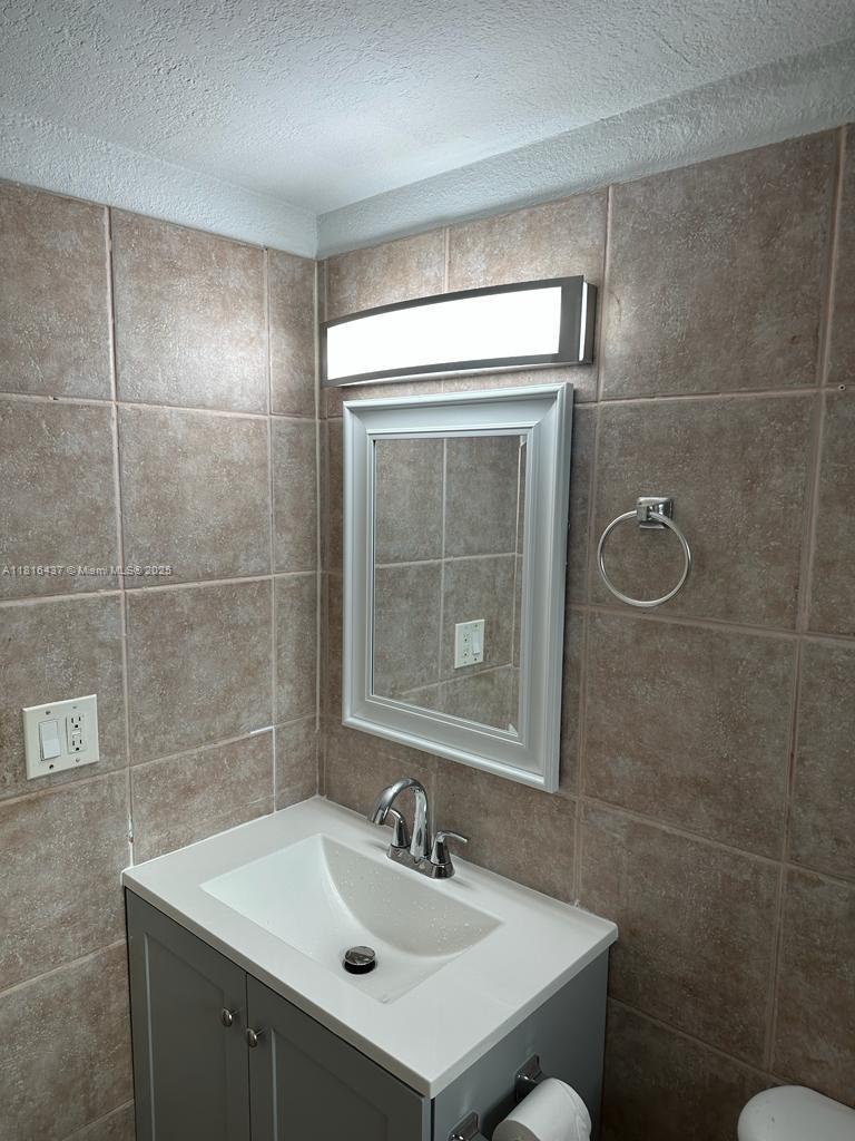 2607 Northeast 8th Avenue, Unit 19 Wilton Manors, FL 33334 - Photo 10 of 11 a bathroom with a sink a toilet and shower