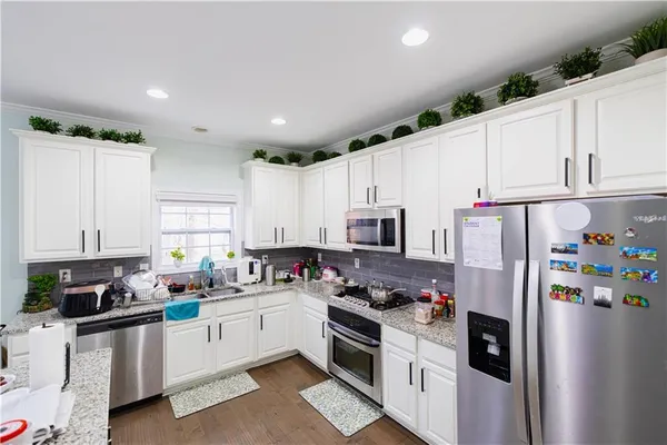a kitchen with stainless steel appliances a refrigerator sink stove and cabinets