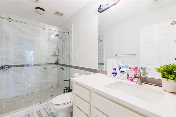 a bathroom with a sink vanity mirror and toilet
