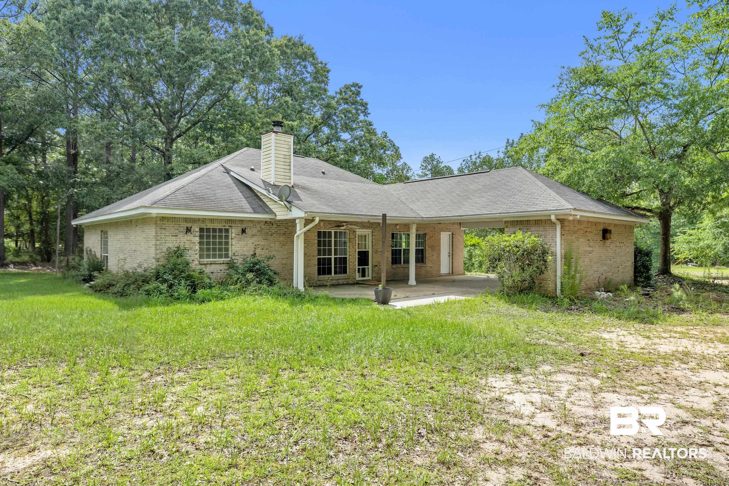 14960 Howells Ferry Road Wilmer, AL 36587 - Photo 5 of 22 Rear exterior featuring a brick facade, covered patio, and a shingled roof