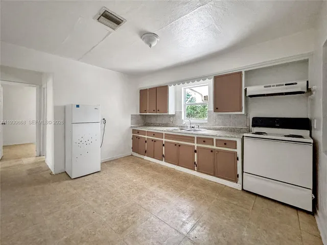 a kitchen with white cabinets and white appliances