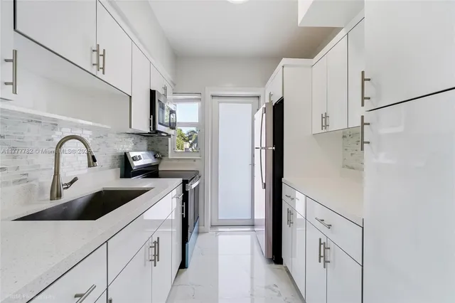 a kitchen with white cabinets and refrigerator