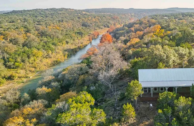an aerial view of house with yard and mountain view in back