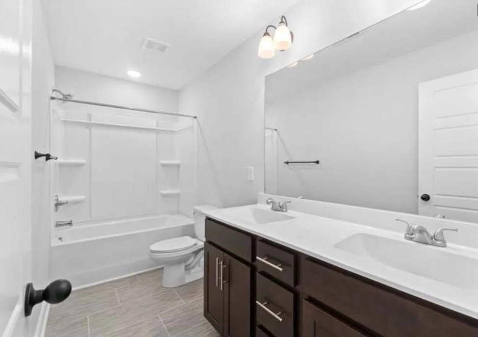 64 West High Street Clarksville, TN 37040 - Photo 12 of 18 a bathroom with a double vanity sink toilet mirror and bathtub