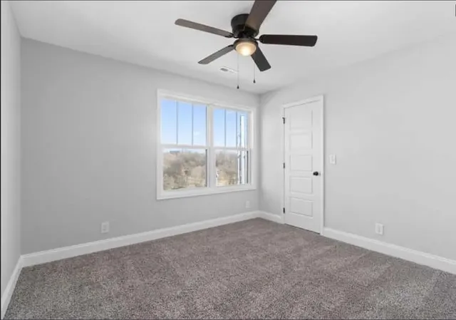 an empty room with a empty space and a ceiling fan