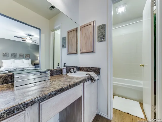 a bathroom with a granite countertop sink and a mirror