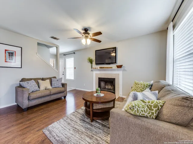a living room with furniture a fireplace and a flat screen tv