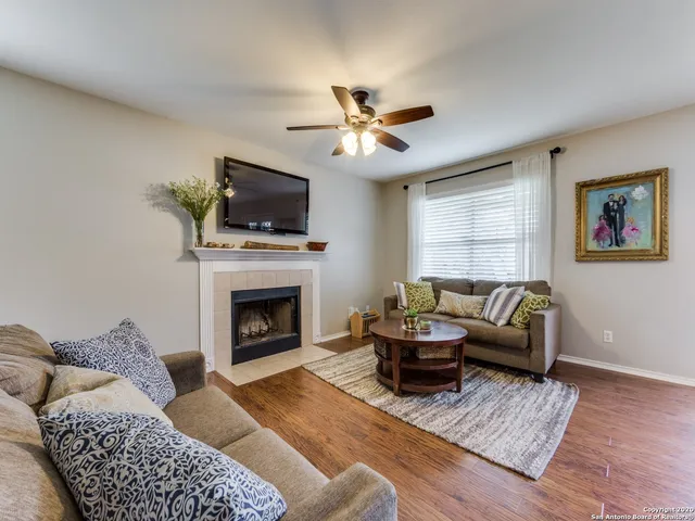 a living room with furniture a flat screen tv and a fireplace