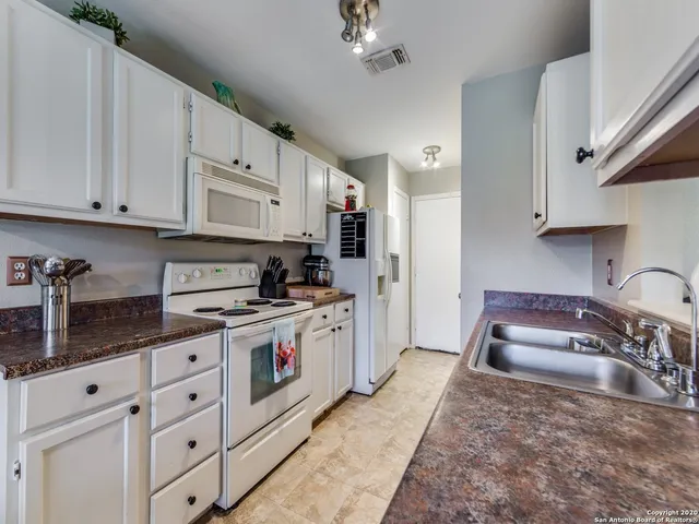 a kitchen with granite countertop a sink stainless steel appliances and cabinets