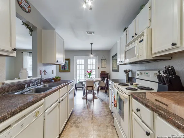 a large kitchen with stainless steel appliances granite countertop a lot of counter space and a sink