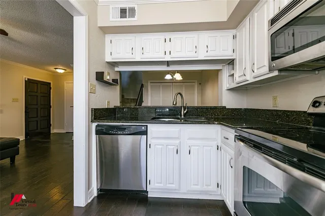 a kitchen with stainless steel appliances granite countertop a sink and cabinets