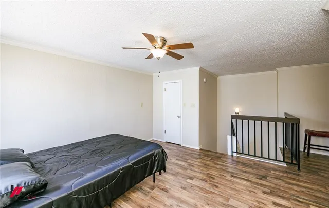 a bedroom with bed and wooden floor