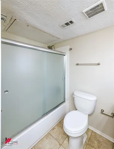 a white toilet sitting next to a shower