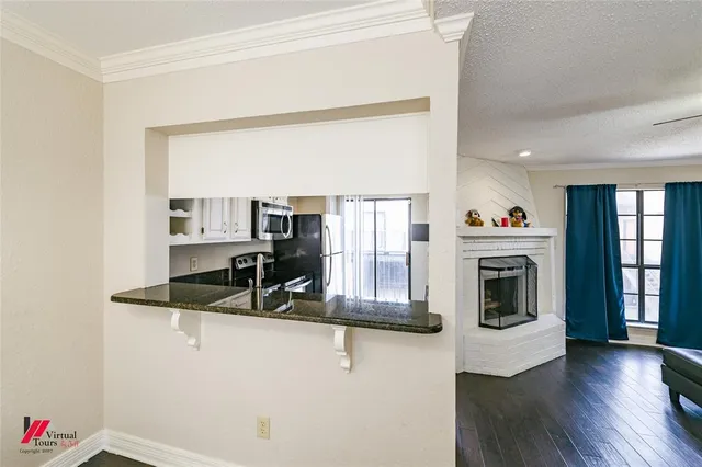 a kitchen with stainless steel appliances granite countertop a sink a stove and a wooden floors