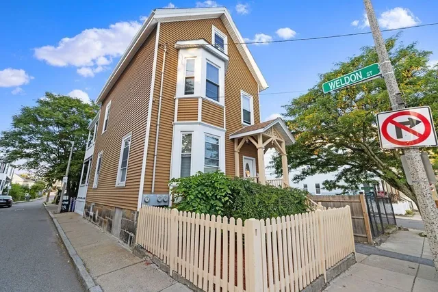 a front view of a house with a tree
