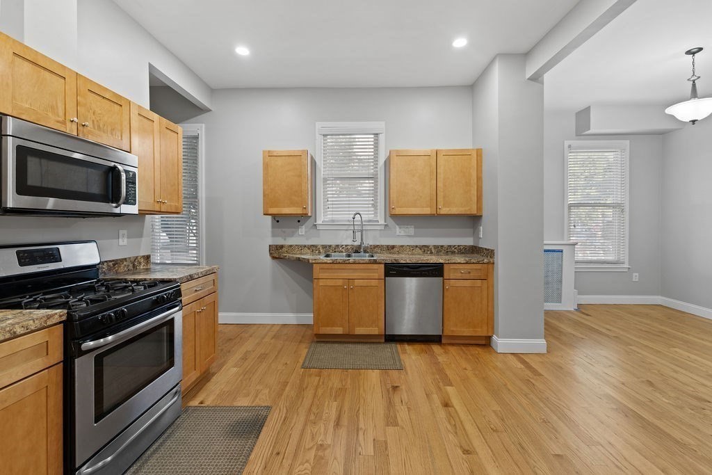 18 Holborn Street Boston, MA 02121 - Photo 3 of 33 a kitchen with stainless steel appliances granite countertop a stove a sink and a microwave