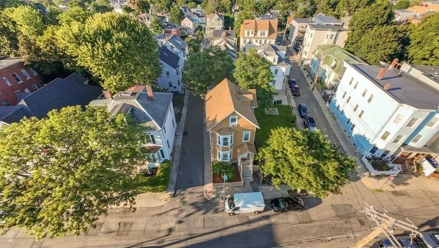 an aerial view of a house with a yard potted plants and large tree