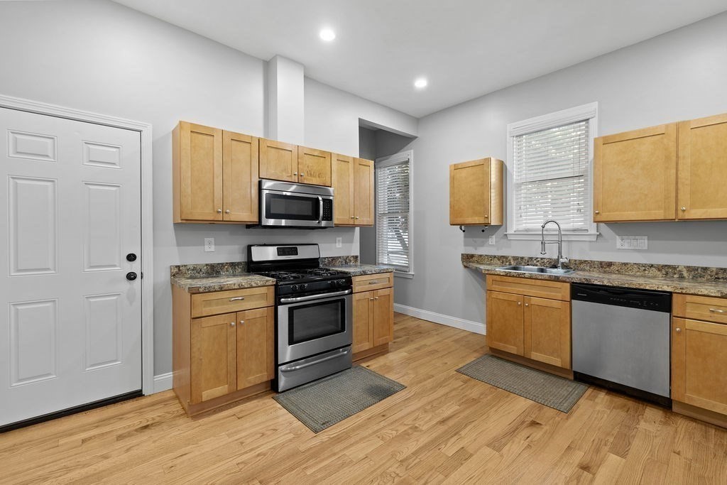 18 Holborn Street Boston, MA 02121 - Photo 4 of 33 a kitchen with stainless steel appliances granite countertop a stove a sink and a microwave