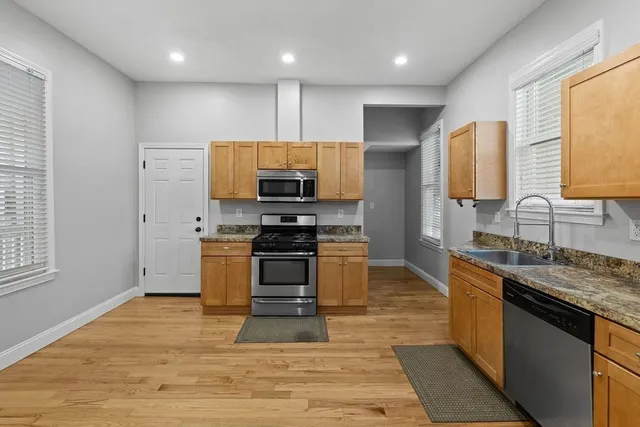 a kitchen with stainless steel appliances kitchen island granite countertop a stove a sink and a microwave
