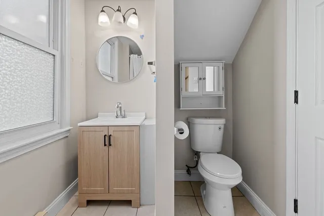 a bathroom with a toilet a sink and mirror