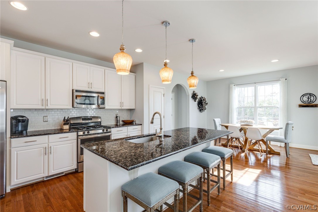 1348 Miners Trail Road Midlothian, VA 23114 - Photo 13 of 49 a kitchen with granite countertop a stove a sink a dining table and chairs