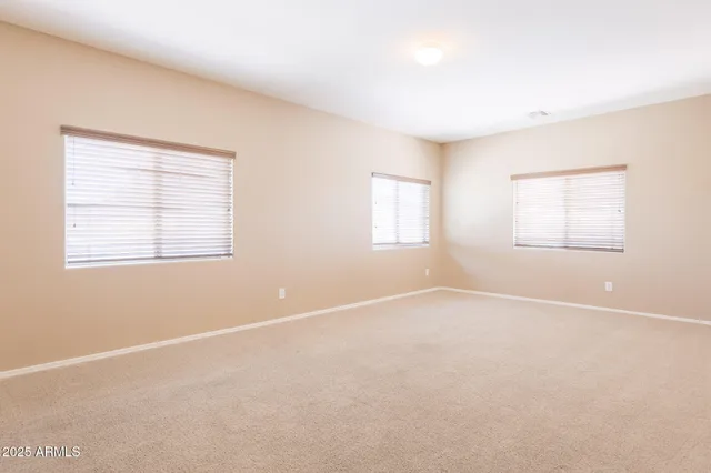 an empty room with a ceiling fan and a window