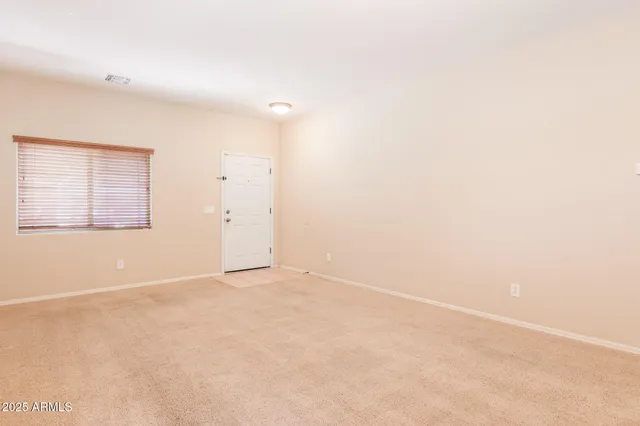 an empty room with chandelier fan and windows