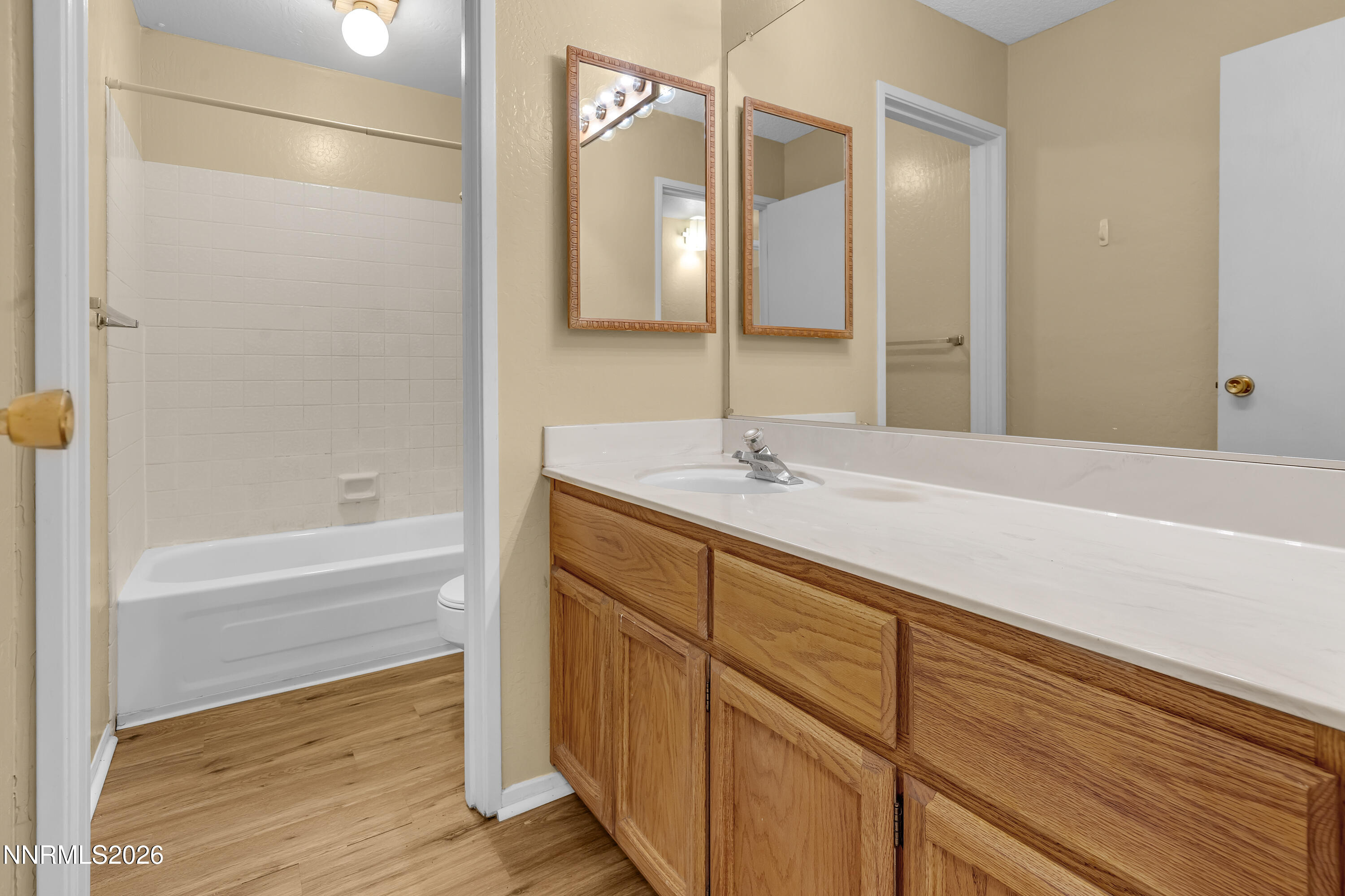 2845 Idlewild Drive, Unit 204 Reno, NV 89509 - Photo 18 of 29 a bathroom with a double vanity sink a mirror and a bathtub