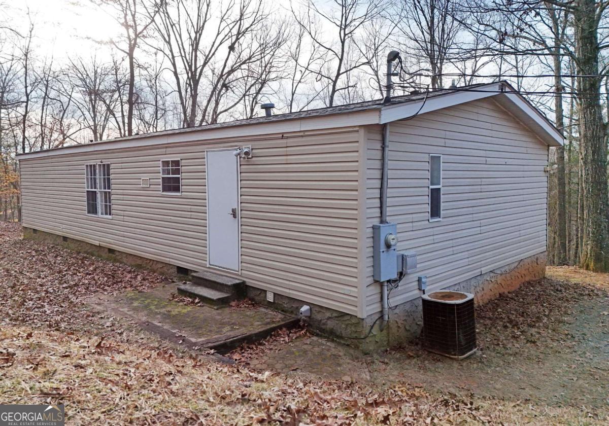 273 Rose Ray Road Ellijay, GA 30540 - Photo 16 of 32 a side view of a house with a yard and wooden fence