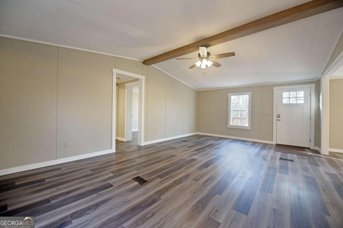 273 Rose Ray Road Ellijay, GA 30540 - Photo 19 of 32 a view of empty room with wooden floor and fan
