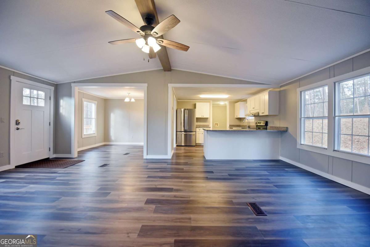 273 Rose Ray Road Ellijay, GA 30540 - Photo 2 of 32 a view of an empty room with window and wooden floor