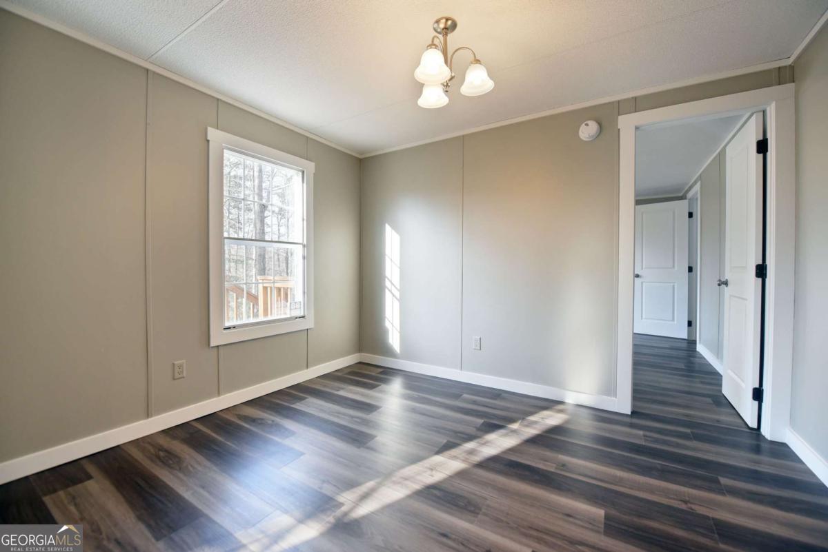 273 Rose Ray Road Ellijay, GA 30540 - Photo 27 of 32 an empty room with wooden floor and windows