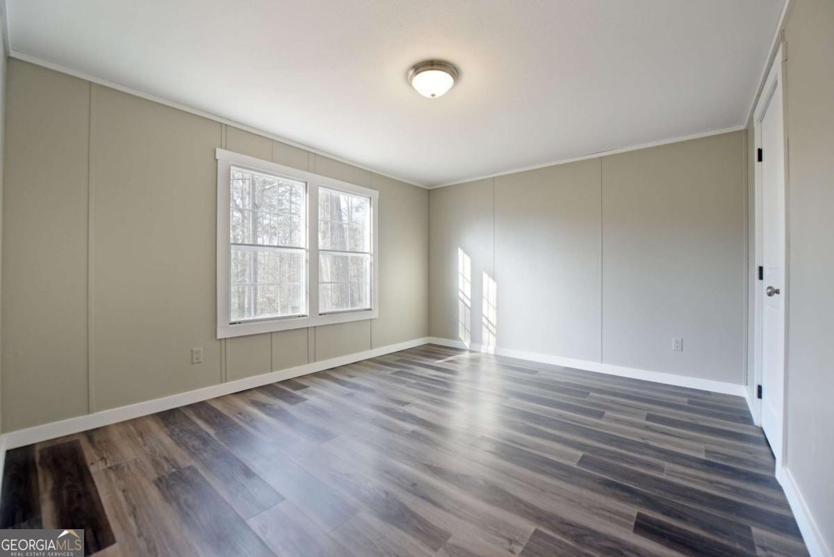 273 Rose Ray Road Ellijay, GA 30540 - Photo 28 of 32 an empty room with wooden floor and windows